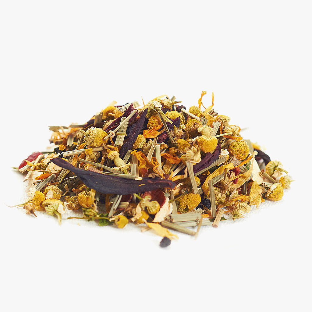 A pile of loose Entspann Dich tea blend, featuring dried chamomile flowers, hibiscus petals, lemongrass, and other herbs, creates a relaxing tea on a white background.